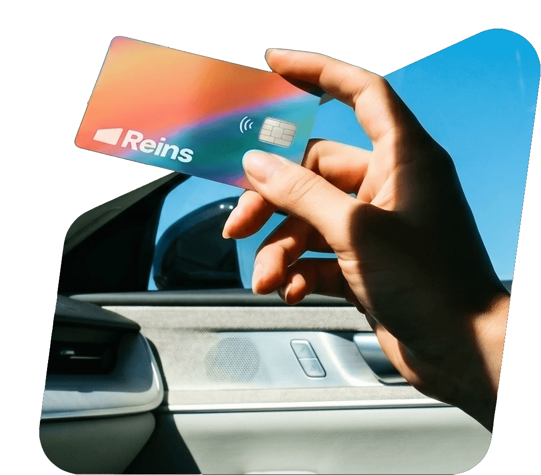 Hand holding a Reins fleet card inside a car