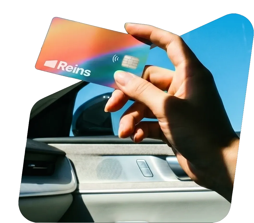 Hand holding a Reins fleet card inside a car
