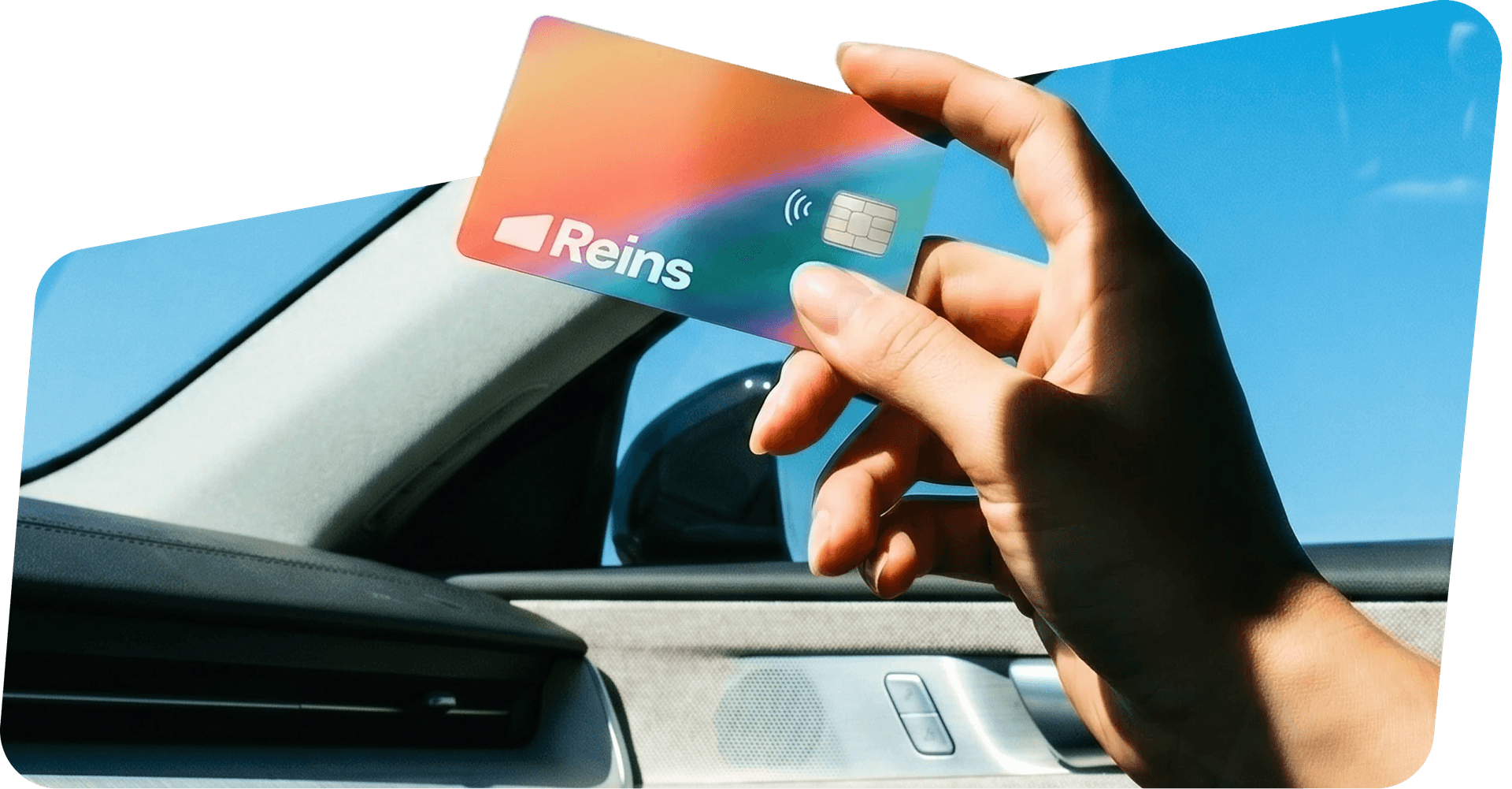 Hand holding a Reins fleet card inside a car