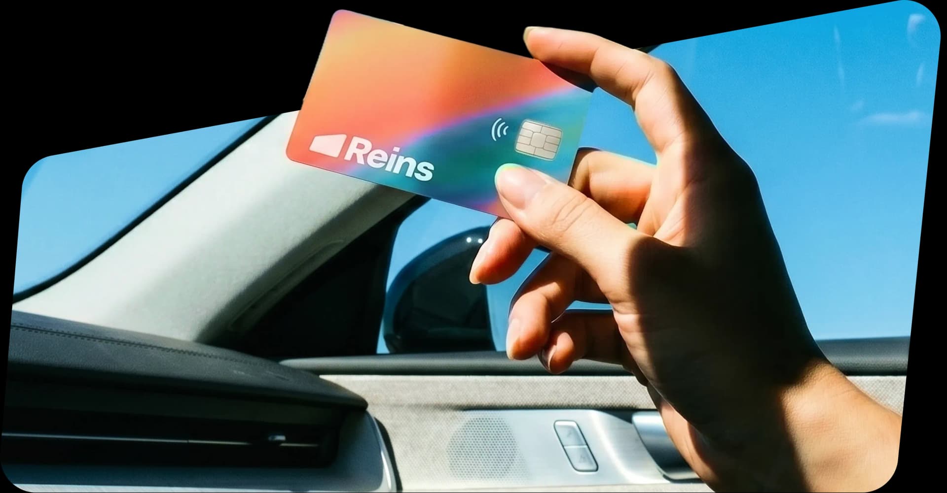 Hand holding a Reins fleet card inside a car